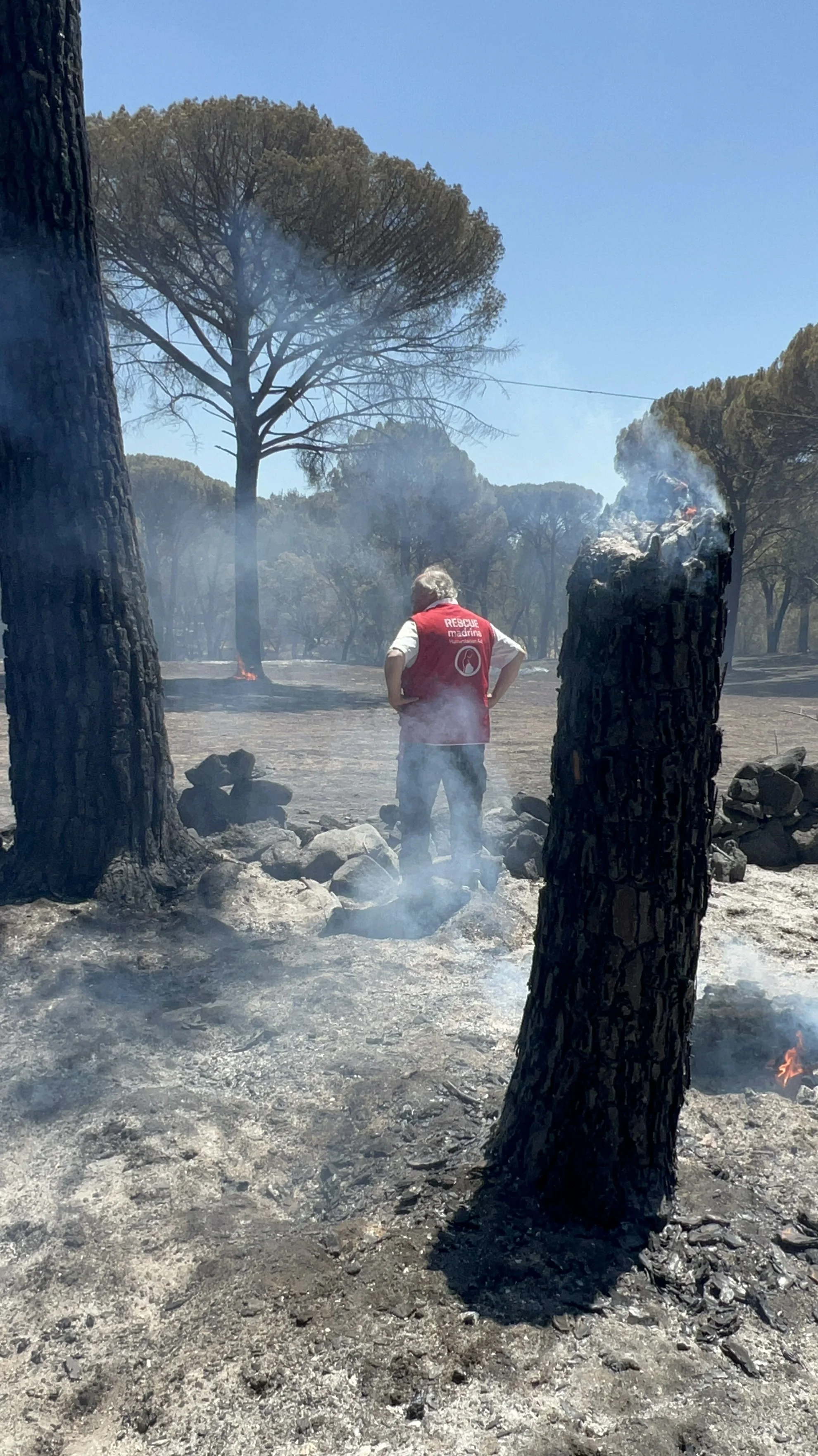 Voluntario frente al paisaje calcinado tras el incendio